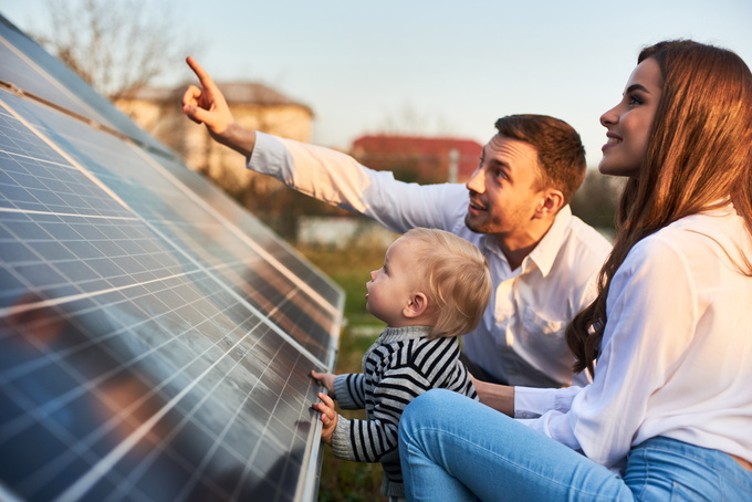 Familie mit Kind betrachtet eine Solaranlage